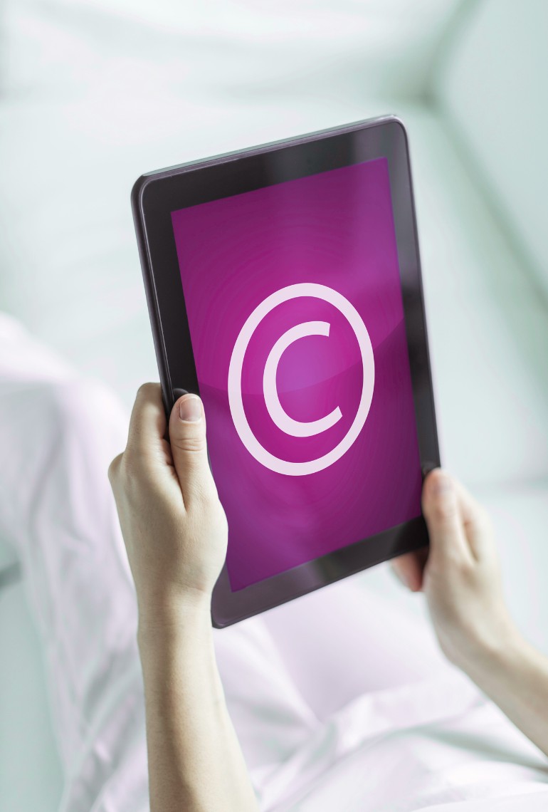 Tablet displaying a copyright symbol, illustrating the protection of creative works and document timestamping using blockchain technology